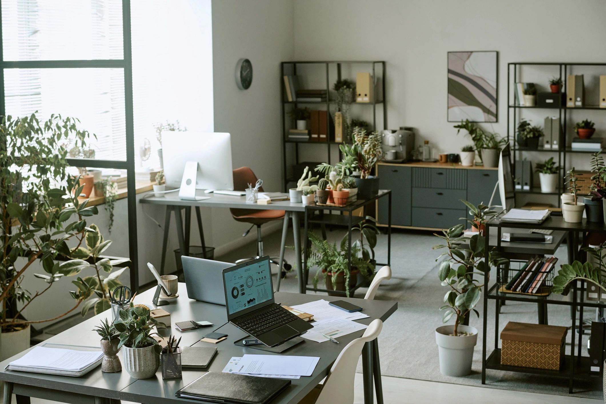 Modern consulting office workspace with desks and laptops